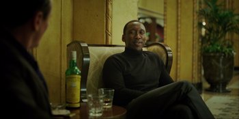 Movie still from “Green Book” (2018), directed by Peter Farrelly – A man sitting at a table with a bottle of wine; Medium shot, Over the shoulder angle
