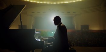 Movie still from “Green Book” (2018), directed by Peter Farrelly – A man sitting in front of a piano in a concert hall; Extreme Wide shot, Low angle
