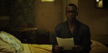Movie still from “Green Book” (2018), directed by Peter Farrelly – A man sitting on a bed holding a piece of paper; Close Up shot, Over the shoulder angle