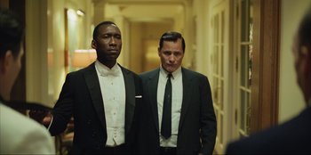 Movie still from “Green Book” (2018), directed by Peter Farrelly – Two men in suits standing next to each other in a hallway; Medium shot, Low angle