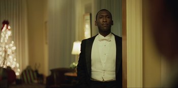 Movie still from “Green Book” (2018), directed by Peter Farrelly – A man in a tuxedo standing in front of a wall; Medium shot, Low angle