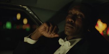 Movie still from “Green Book” (2018), directed by Peter Farrelly – A man in a black suit and white shirt holding a cane; Close Up shot, Low angle