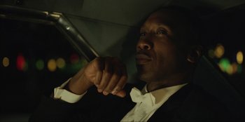 Movie still from “Green Book” (2018), directed by Peter Farrelly – A man sitting in a car with his hand resting on his chin; Close Up shot, Low angle