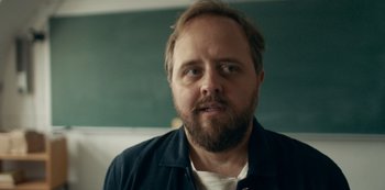 Movie still from “Another Round” (2020), directed by Thomas Vinterberg – A man with a goatee is looking at the camera; Close Up shot, Over the shoulder angle