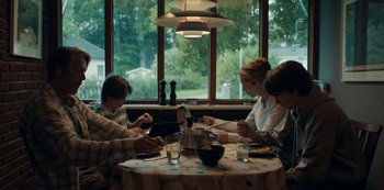 Movie still from “Another Round” (2020), directed by Thomas Vinterberg – A group of people sitting at a table with food; Wide shot, Low angle