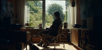 Movie still from “Another Round” (2020), directed by Thomas Vinterberg – A man sitting in a chair in front of a window; Wide shot, Low angle