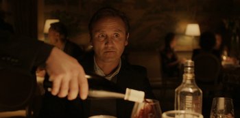 Movie still from “Another Round” (2020), directed by Thomas Vinterberg – A man sitting at a table with a knife in his hand; Close Up shot, Over the shoulder angle