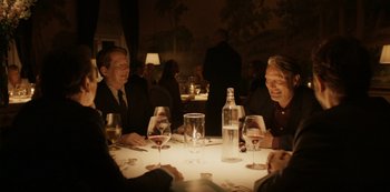 Movie still from “Another Round” (2020), directed by Thomas Vinterberg – A group of people sitting around a table with wine; Medium shot, Over the shoulder angle