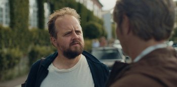 Movie still from “Another Round” (2020), directed by Thomas Vinterberg – A man with a goatee talking to another man; Close Up shot, Over the shoulder angle