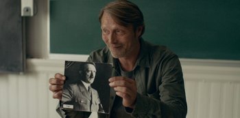 Movie still from “Another Round” (2020), directed by Thomas Vinterberg – A man holding up a picture of adolf hitler; Close Up shot, Over the shoulder angle