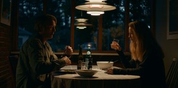 Movie still from “Another Round” (2020), directed by Thomas Vinterberg – A man and a woman sitting at a dinner table; Medium shot, Low angle
