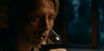 Movie still from “Another Round” (2020), directed by Thomas Vinterberg – A person holding a glass of red wine; Close Up shot, High angle
