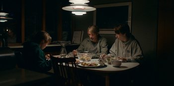 Movie still from “Another Round” (2020), directed by Thomas Vinterberg – A group of people sitting at a dinner table; Medium shot, High angle