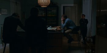 Movie still from “Another Round” (2020), directed by Thomas Vinterberg – A man sitting at a table with a plate of food; Wide shot, Over the shoulder angle