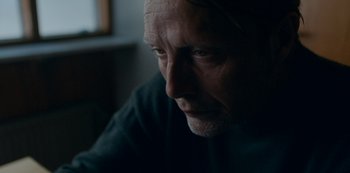 Movie still from “Another Round” (2020), directed by Thomas Vinterberg – A man's face in a dark room; Close Up shot, Over the shoulder angle