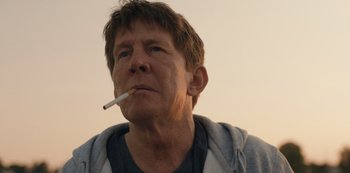 Movie still from “Another Round” (2020), directed by Thomas Vinterberg – A person with a cigarette in his mouth; Close Up shot, Low angle