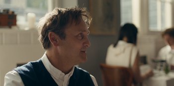 Movie still from “Another Round” (2020), directed by Thomas Vinterberg – A person sitting in a room; Close Up shot, Over the shoulder angle