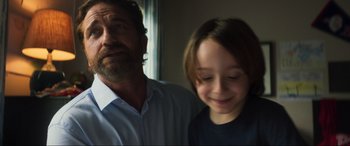 Movie still from “Greenland” (2020), directed by Ric Roman Waugh – A man standing next to a young boy; Close Up shot, Over the shoulder angle