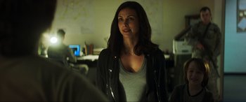 Movie still from “Greenland” (2020), directed by Ric Roman Waugh – A woman standing in front of a mirror in a room; Close Up shot, Over the shoulder angle