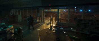 Movie still from “Greenland” (2020), directed by Ric Roman Waugh – A person walking in a room with a lot of trash on the floor; Extreme Wide shot, Low angle