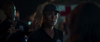 Movie still from “Greenland” (2020), directed by Ric Roman Waugh – A woman wearing a baseball cap is looking at the camera; Close Up shot, Over the shoulder angle