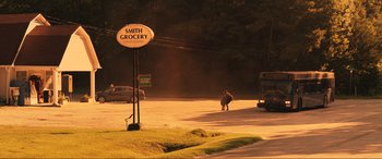 Movie still from “Greenland” (2020), directed by Ric Roman Waugh – A person walking down a street near a street sign; Extreme Wide shot, High angle