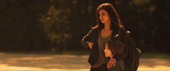Movie still from “Greenland” (2020), directed by Ric Roman Waugh – A woman standing next to a young boy in a park; Medium shot, Over the shoulder angle