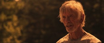 Movie still from “Greenland” (2020), directed by Ric Roman Waugh – An old man with a beard and a white beard; Close Up shot, Over the shoulder angle