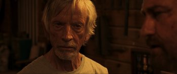 Movie still from “Greenland” (2020), directed by Ric Roman Waugh – An old man with white hair is looking at the camera; Close Up shot, Over the shoulder angle