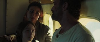 Movie still from “Greenland” (2020), directed by Ric Roman Waugh – A man and a woman and a child on a plane; Close Up shot, Over the shoulder angle