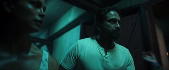 Movie still from “Greenland” (2020), directed by Ric Roman Waugh – A man in white shirt standing next to a wall; Close Up shot, Low angle
