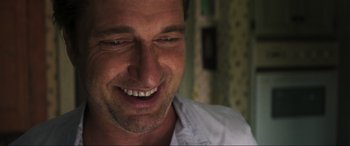 Movie still from “Greenland” (2020), directed by Ric Roman Waugh – A man smiling with his mouth wide open; Close Up shot, Low angle