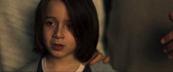 Movie still from “Greenland” (2020), directed by Ric Roman Waugh – A person with a hand on the shoulder of a child; Close Up shot, Over the shoulder angle