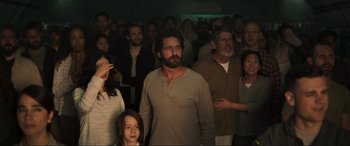 Movie still from “Greenland” (2020), directed by Ric Roman Waugh – A group of people standing in front of a crowd; Medium shot, Low angle