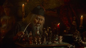 Movie still from “Gremlins” (1984), directed by Joe Dante – An old man is playing chess in front of candles; Medium shot, High angle
