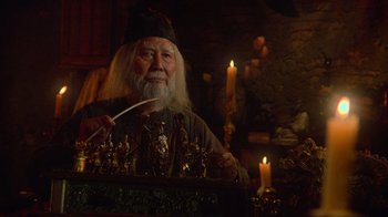 Movie still from “Gremlins” (1984), directed by Joe Dante – An old man with long white hair and a long white beard; Medium shot, Low angle