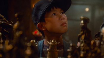 Movie still from “Gremlins” (1984), directed by Joe Dante – A young boy wearing a hat looking up at the sky; Close Up shot, Over the shoulder angle