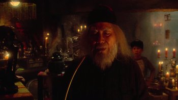 Movie still from “Gremlins” (1984), directed by Joe Dante – An old man with long white hair and a beard; Medium shot, Over the shoulder angle