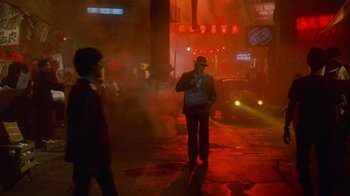 Movie still from “Gremlins” (1984), directed by Joe Dante – A man standing on the side of a road; Wide shot, Low angle