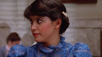 Movie still from “Gremlins” (1984), directed by Joe Dante – A young woman with dark brown hair wearing a blue dress; Close Up shot, Over the shoulder angle