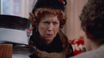 Movie still from “Gremlins” (1984), directed by Joe Dante – An older woman wearing a fur coat and a hat; Close Up shot, Over the shoulder angle