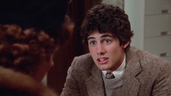 Movie still from “Gremlins” (1984), directed by Joe Dante – A young man in a brown jacket and a tie; Close Up shot, Over the shoulder angle