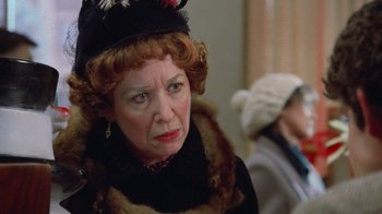 Movie still from “Gremlins” (1984), directed by Joe Dante – An older woman wearing a hat and a fur coat; Close Up shot, Over the shoulder angle