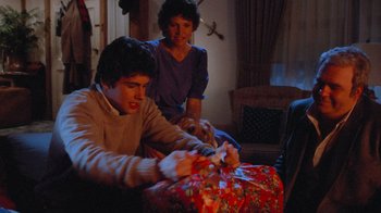 Movie still from “Gremlins” (1984), directed by Joe Dante – A man and a woman wrapping a christmas present; Medium shot, High angle