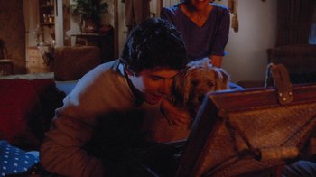 Movie still from “Gremlins” (1984), directed by Joe Dante – A man and a dog are looking at a laptop computer; Medium shot, High angle