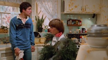 Movie still from “Gremlins” (1984), directed by Joe Dante – Two young boys in a kitchen with a bunch of plants in the kitchen; Medium shot, Over the shoulder angle