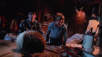 Movie still from “Gremlins” (1984), directed by Joe Dante – Two young boys are playing a board game in the dark; Medium shot, Over the shoulder angle