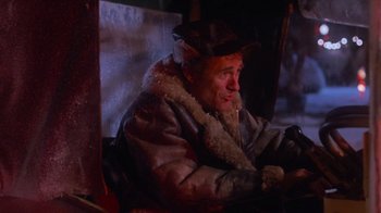 Movie still from “Gremlins” (1984), directed by Joe Dante – An old man sitting in a chair wearing a hat; Close Up shot, High angle