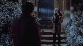 Movie still from “Gremlins” (1984), directed by Joe Dante – Two people standing in front of a door; Wide shot, Over the shoulder angle