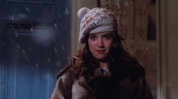 Movie still from “Gremlins” (1984), directed by Joe Dante – A young woman wearing a white hat and a brown coat; Close Up shot, Over the shoulder angle